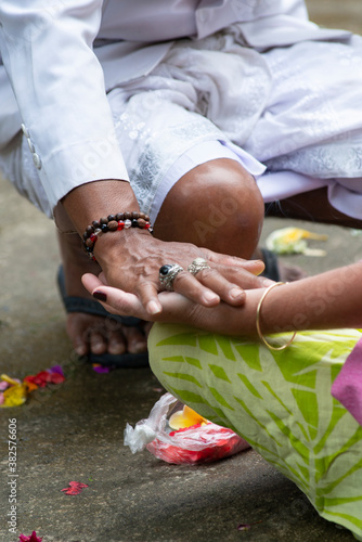 Priest blessing a tourist at a balinese temple, Bali, Indonesia
