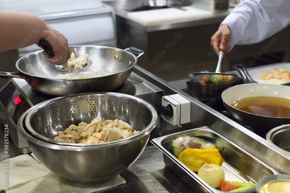 Professional cooks prepare a meal in a restaurant kitchen Professional cooks prepare a meal in a restaurant kitchen