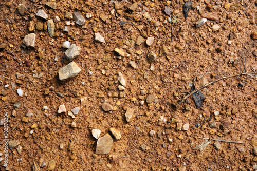 Moist yellow soil with lots of small stones  detailed texture