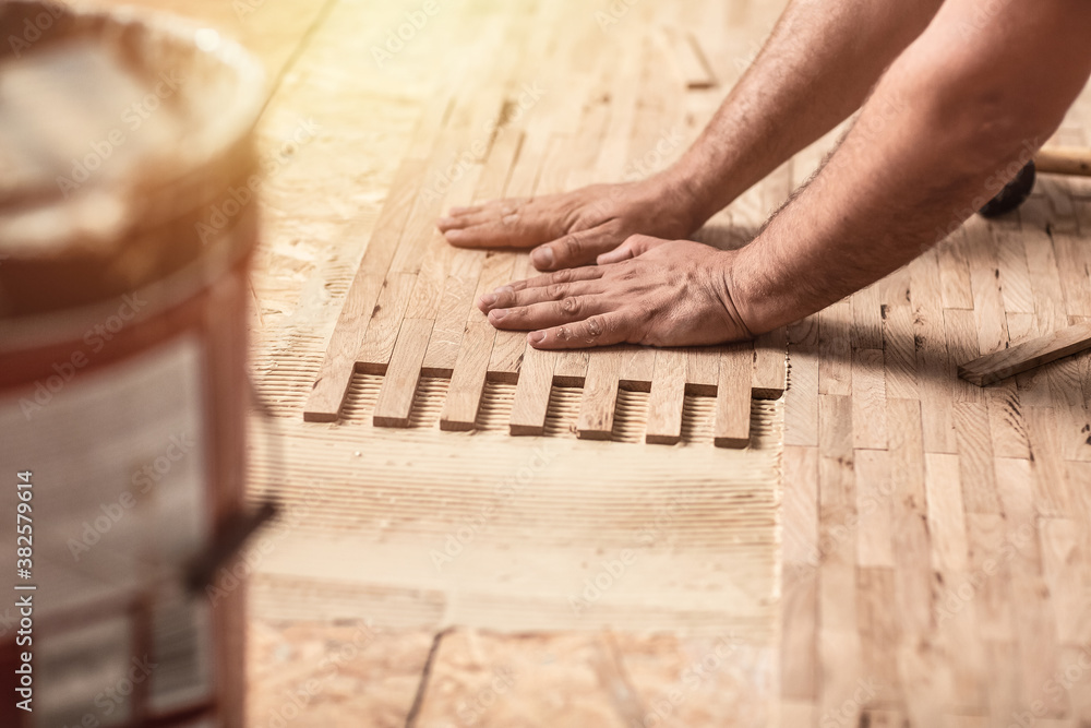 close up of worker installing wood parquet. Carpenter on work putting wood parquet pieces close up of worker installing wood parquet. Carpenter on work putting wood parquet pieces