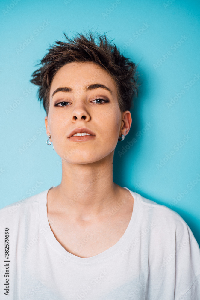 Portrait of beautiful shorthair woman against the blue wall Portrait of beautiful shorthair woman against the blue wall