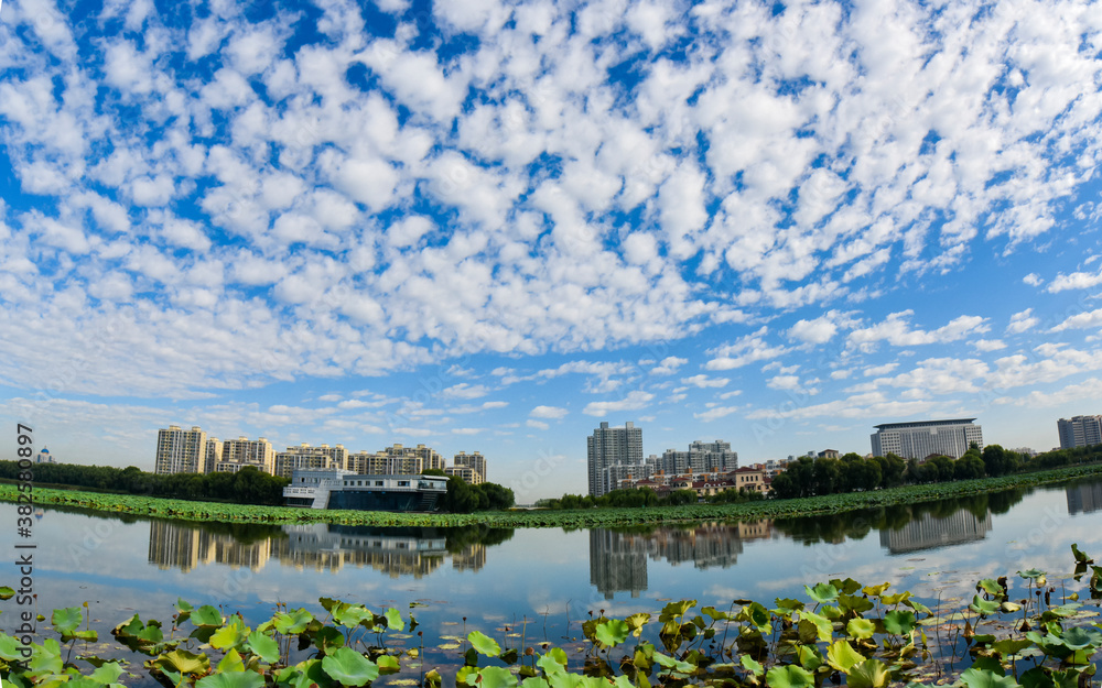 Blue sky and white clouds in the background of waterfront city skyline scenery, LUANNAN COUNTY, Hebei Province, China.
