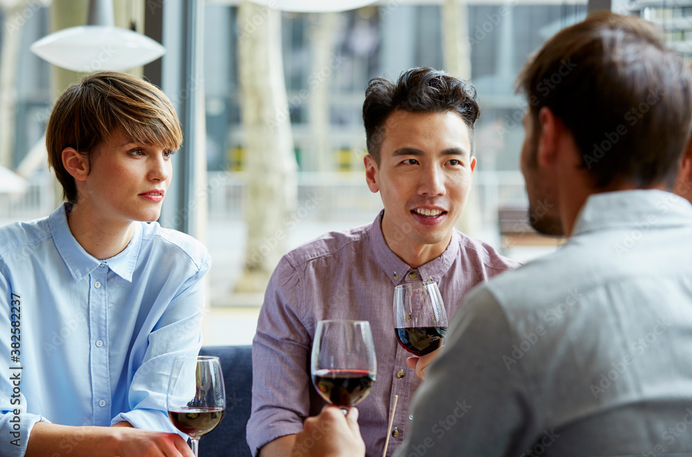 Friends Having Wine While Talking In Restaurant Friends Having Wine While Talking In Restaurant
