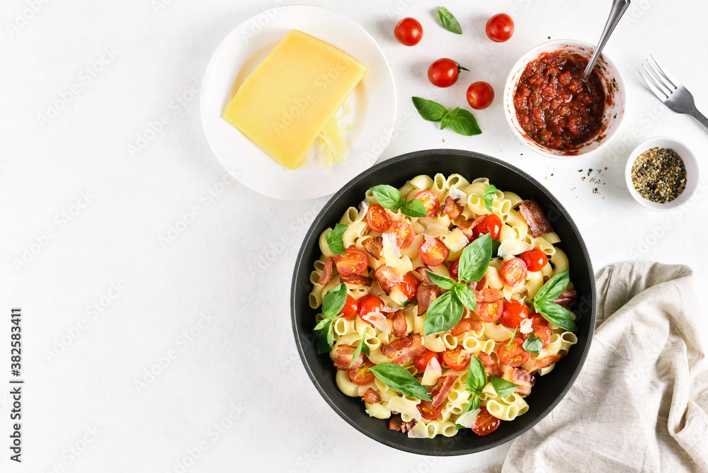 Tomato and bacon pasta with parmesan cheese and basil leaves Tomato and bacon pasta with parmesan cheese and basil leaves