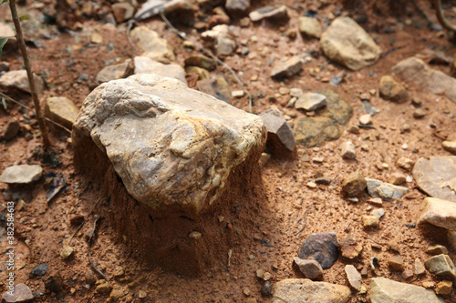 Stones on moist yellow soil, detailed texture
