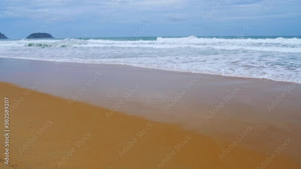 Landscapes view of waves breaking on beach sand and the sky on a stormy rainy season Landscapes view of waves breaking on beach sand and the sky on a stormy rainy season