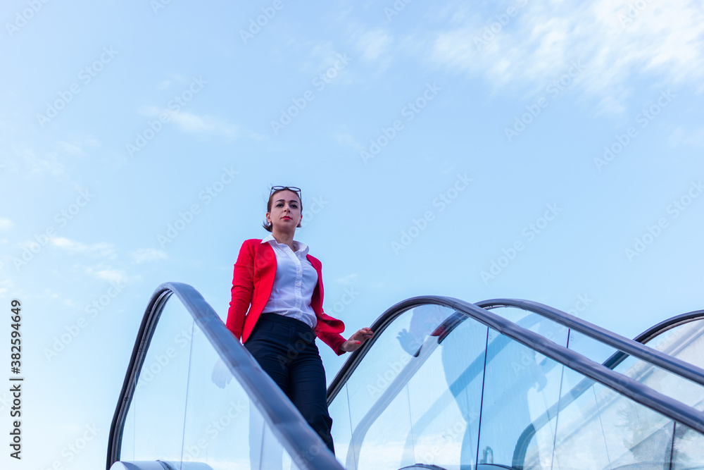 business woman goes down the escalator business woman goes down the escalator