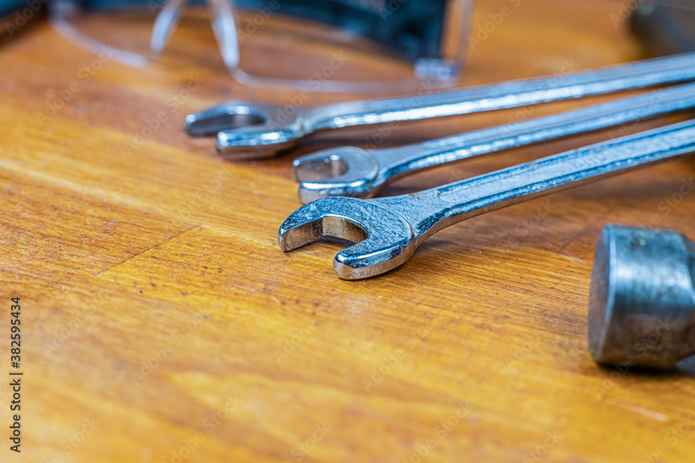 set hand tool a pair of wrenches close-up and a hammer, selective focus, lies on a wooden background set hand tool a pair of wrenches close-up and a hammer, selective focus, lies on a wooden background