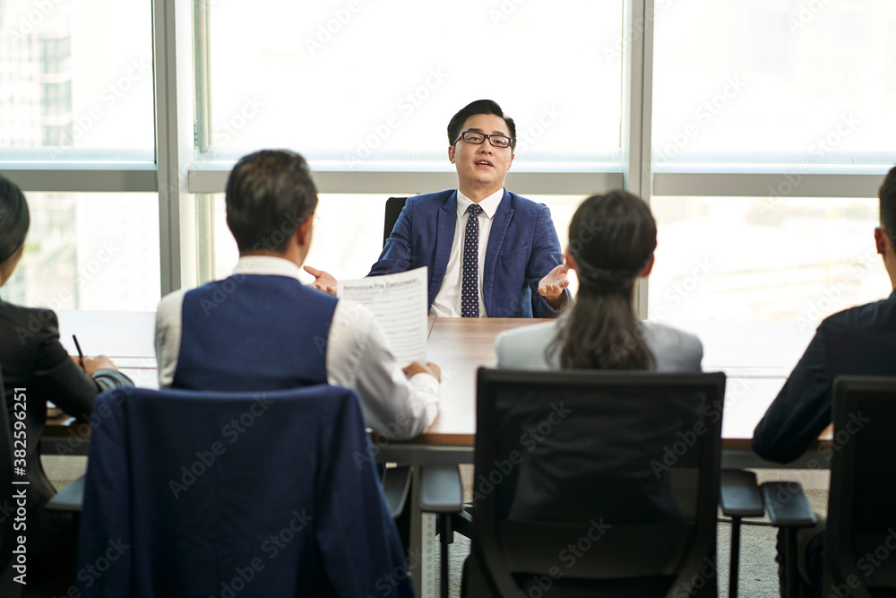 young asian job candidate talking big during a group interview young asian job candidate talking big during a group interview
