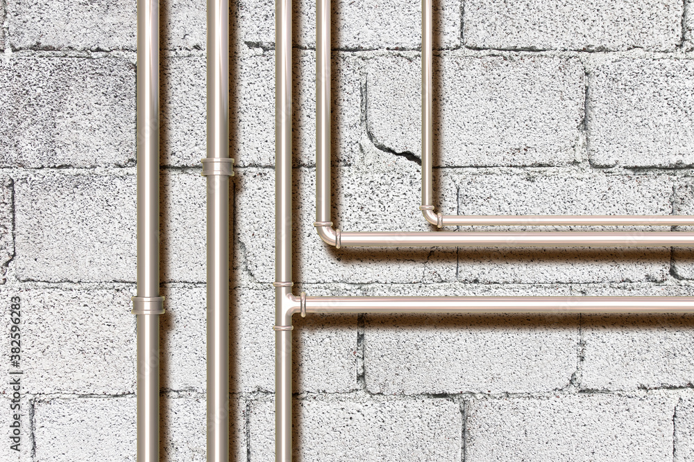 Water and gas metal pipeline in front of a concrete wall Water and gas metal pipeline in front of a concrete wall