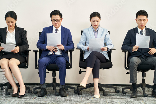 asian businesspeople waiting in line for job interview