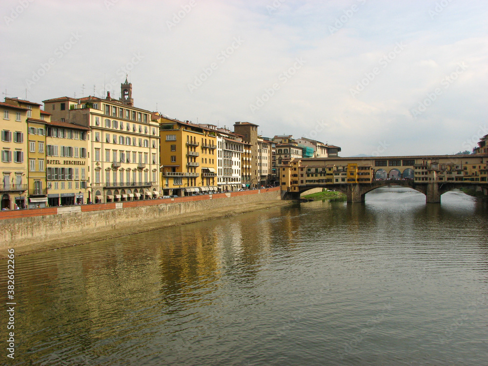 Florence, Italy - October 1 2006 - Ponte Vecchio, a medieval stone covered bridge over the Arno River. It was first built in 996 and is known for shops lining it. Image has copy space.