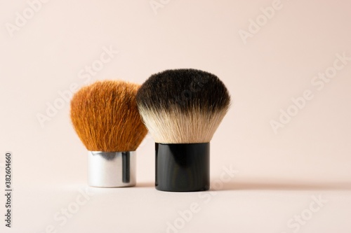 Obraz na plátně Two Kabuki brushes stand next to each other on a pink background