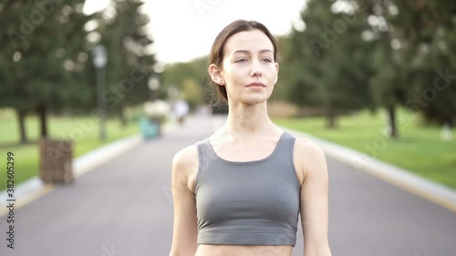 Portrait of youbg sporty woman walking in the park. Slowmotion. photo