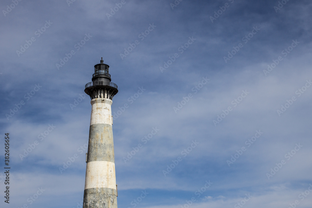 Lighthouse under sunny blue sky with copy space. 