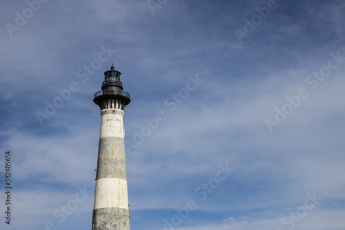 Lighthouse under sunny blue sky with copy space. 