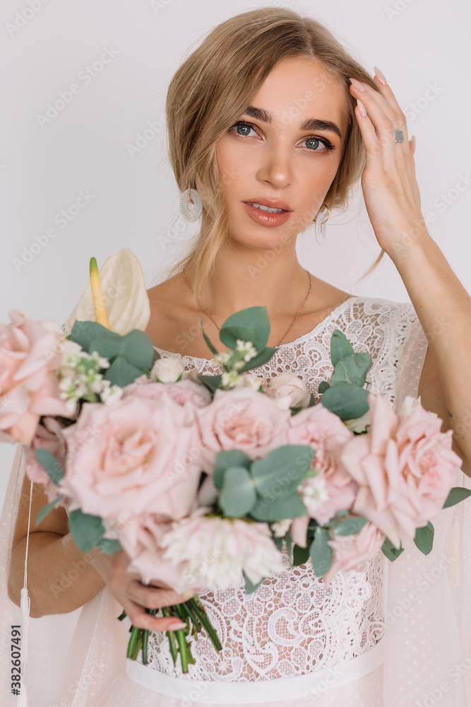 young woman in white wedding dress with long hair before the engagement ceremony with a bouquet of flowers on a white background with a model appearance roses blue eyes young woman in white wedding dress with long hair before the engagement ceremony with a bouquet of flowers on a white background with a model appearance roses blue eyes