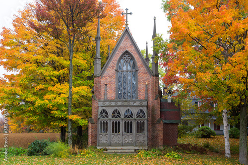 Beautiful red brick gothic revival 1868 Notre-Dame-de-Grace chapel seen during a grey Fall day, Saint-Nicolas, Quebec, Canada © Anne Richard