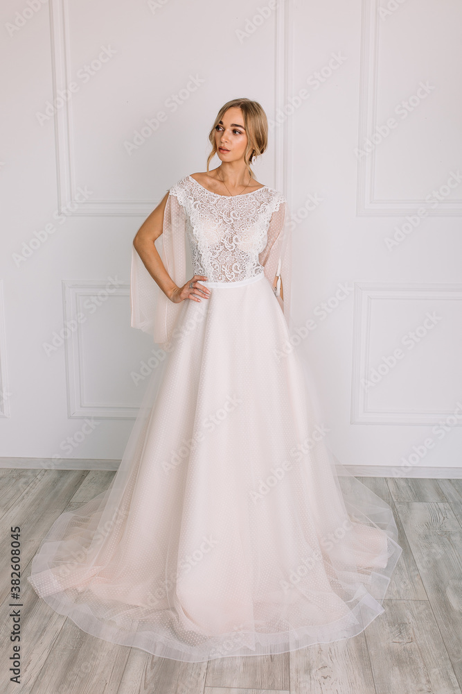 young woman in a white wedding dress with long hair before the engagement ceremony on a white background with a model appearance important wife for the bride posing in front of the photographer
young woman in a white wedding dress with long hair before the engagement ceremony on a white background with a model appearance important wife for the bride posing in front of the photographer
