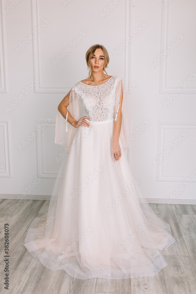 young woman in a white wedding dress with long hair before the engagement ceremony on a white background with a model appearance important wife for the bride posing in front of the photographer
young woman in a white wedding dress with long hair before the engagement ceremony on a white background with a model appearance important wife for the bride posing in front of the photographer