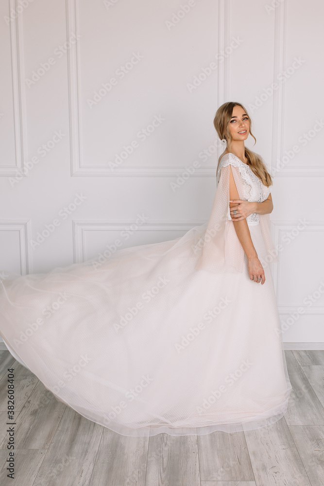 young woman in a white wedding dress with long hair before the engagement ceremony on a white background with a model appearance important wife for the bride posing in front of the photographer
young woman in a white wedding dress with long hair before the engagement ceremony on a white background with a model appearance important wife for the bride posing in front of the photographer