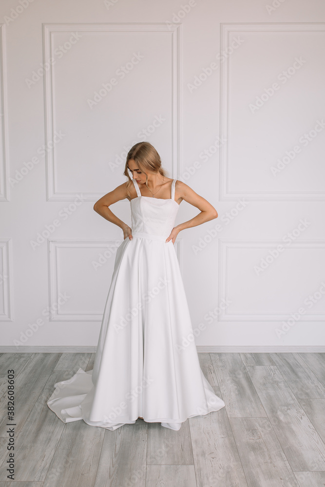 young woman in a white wedding dress with long hair before the engagement ceremony on a white background with a model appearance important wife for the bride posing in front of the photographer
young woman in a white wedding dress with long hair before the engagement ceremony on a white background with a model appearance important wife for the bride posing in front of the photographer