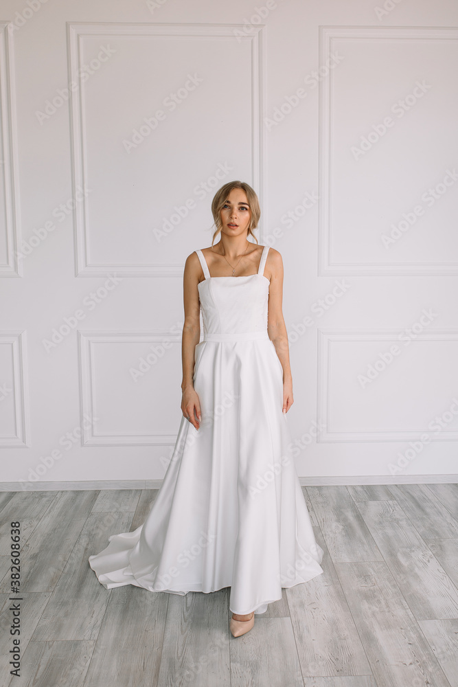 young woman in a white wedding dress with long hair before the engagement ceremony on a white background with a model appearance important wife for the bride posing in front of the photographer
young woman in a white wedding dress with long hair before the engagement ceremony on a white background with a model appearance important wife for the bride posing in front of the photographer