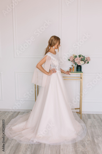 bride in white dress and wedding bouquet in her hands of roses 