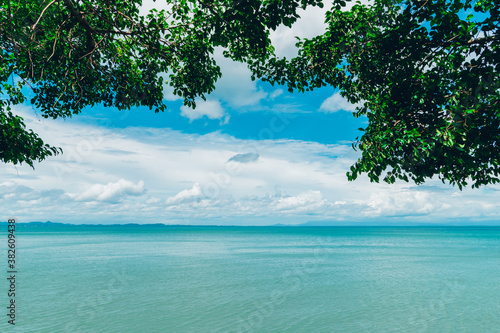 Beautiful sea view from the viewpoint of Koh Chang island , Trat, Thailand with the green leaves of big tree, Blue sea,Sunny day sky and white clouds in summer for holiday vacation background concept.