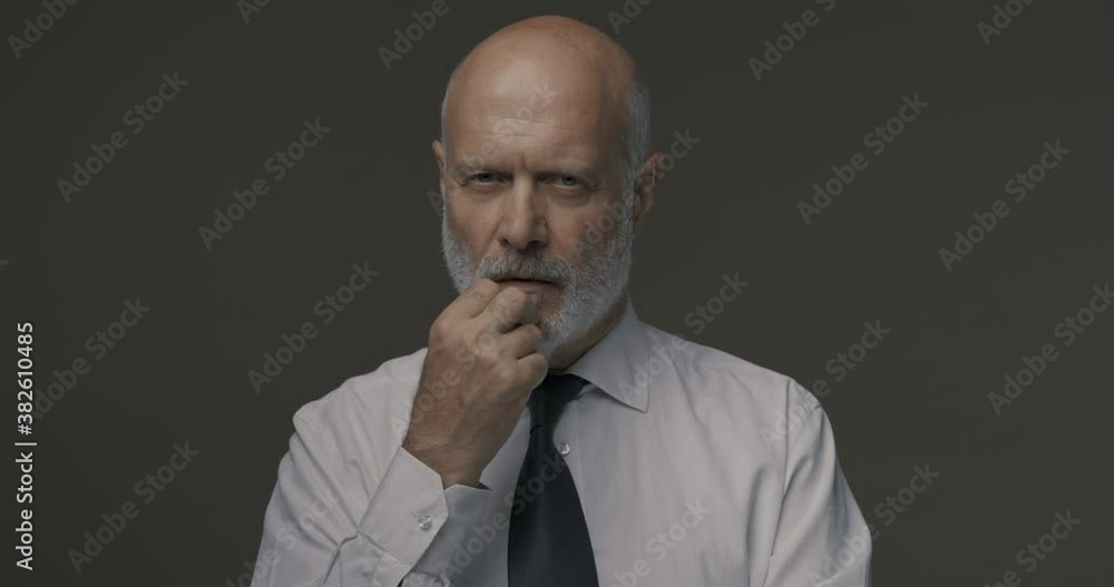 Cheerful businessman pointing upwards and smiling Cheerful businessman pointing upwards and smiling
