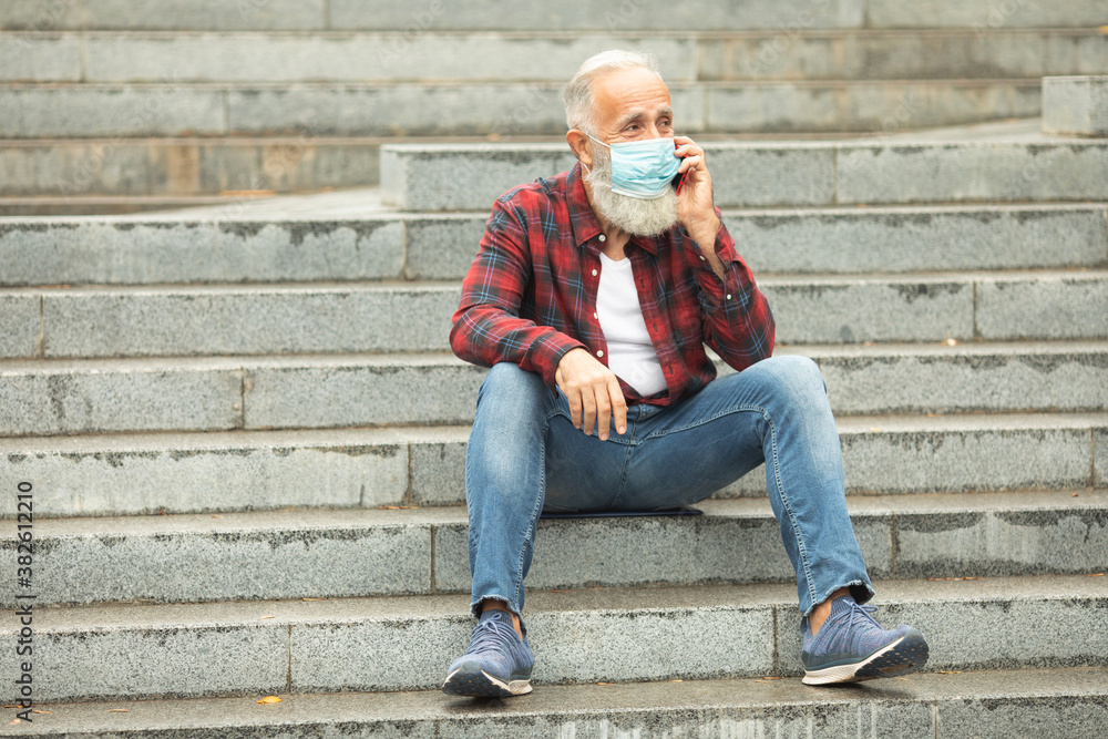 Protective mask most important for old people. Bearded senior man using phone outdoor. Covid-19. Protective mask most important for old people. Bearded senior man using phone outdoor. Covid-19.