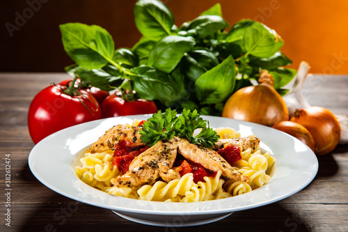Chicken ragout with fusilli on wooden table