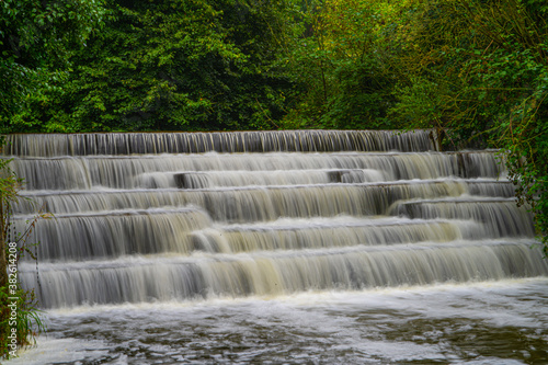 White Water flowing over weir low-level view at long exposure to give blurred motion effects