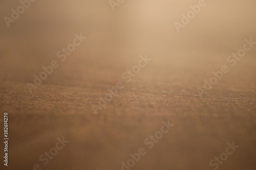 Eine dunkelbraune Holztischoberfläche aus der Nähe fotografiert sodass man die Muster und Verläufe gut erkennt.