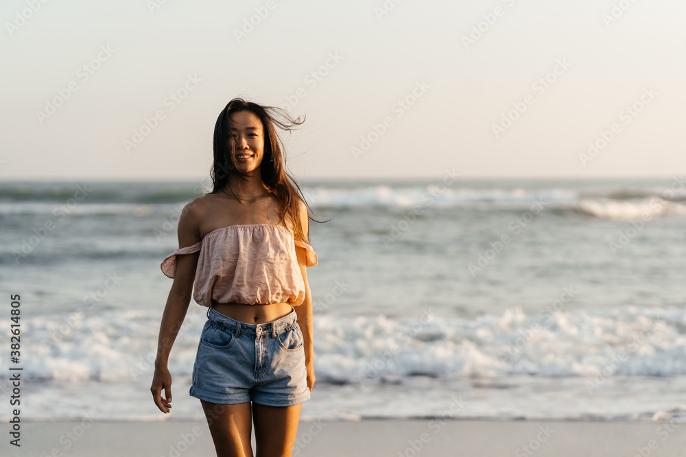 Happy beach girl laughing smiling enjoying sunshine on summer vacation. Gorgeous beautiful young Chinese woman having fun. Happy beach girl laughing smiling enjoying sunshine on summer vacation. Gorgeous beautiful young Chinese woman having fun.