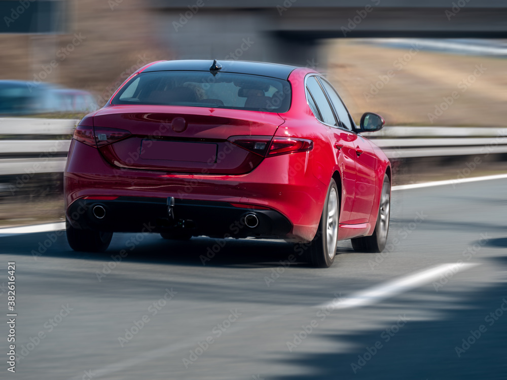 Red sports car on German highway (Autobahn), selective focus blurry background