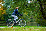Urban biking - woman riding bicycle in city park
