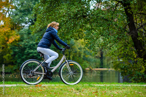 Urban biking - woman riding bicycle in city park 