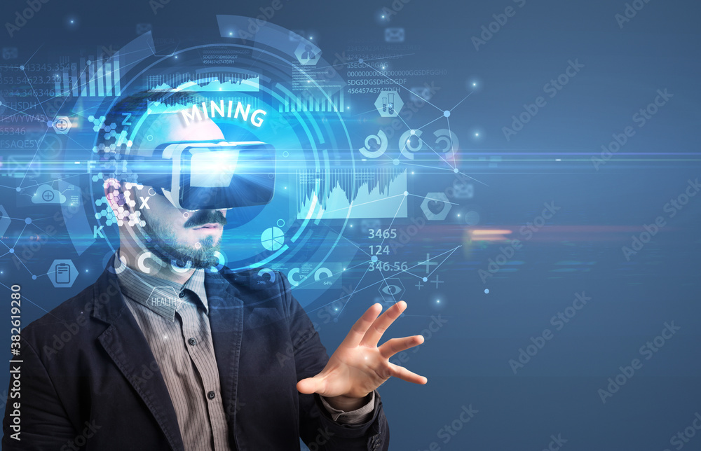 Obraz premium Businessman looking through Virtual Reality glasses with MINING inscription, innovative technology concept