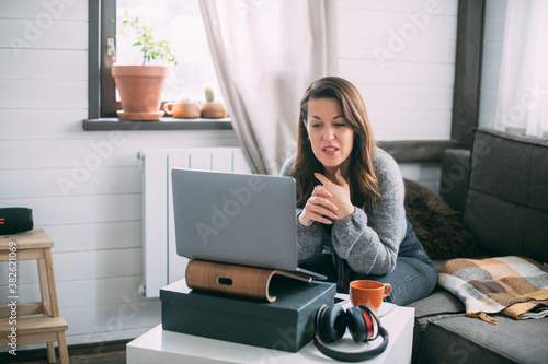 Woman works with laptop at home in the living room