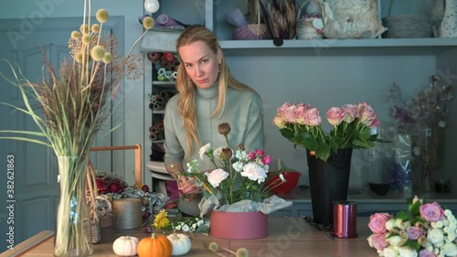 Woman florist creating beautiful bouquet in flower shop. Work in flower shop. Flowers delivery.