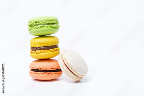 Macaroni, red, yellow, green and white, are stacked one on top of the other in the form of a tower on a white background. Side view