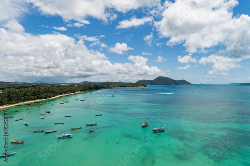 Aerial View Drone shot of Thai traditional longtail fishing boats in the tropical sea beautiful beach in phuket thailand. © panya99