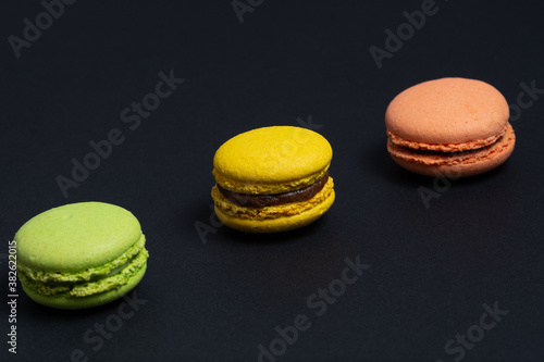 Appetizing pasta of red, green and yellow colors are arranged diagonally on a black background.