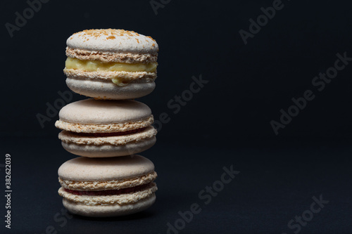 White macaroni are stacked one on top of the other in the form of a tower on a black background. Side view