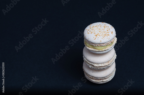 Macaroni, red, yellow and green, are stacked one on top of the other in the form of a tower on a white background. View from above