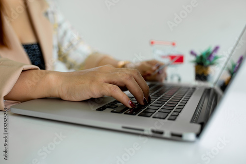 Asian business young woman's hands working new start up project. Finance task.Digital tablet docking keyboard laptop computer smart phone in morning light. Concept business and finance