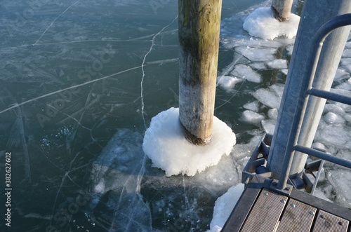 Moos , Bodensee, Deutschland - Gefrorenes Eis am Holfzpfeiler im Hafen photo