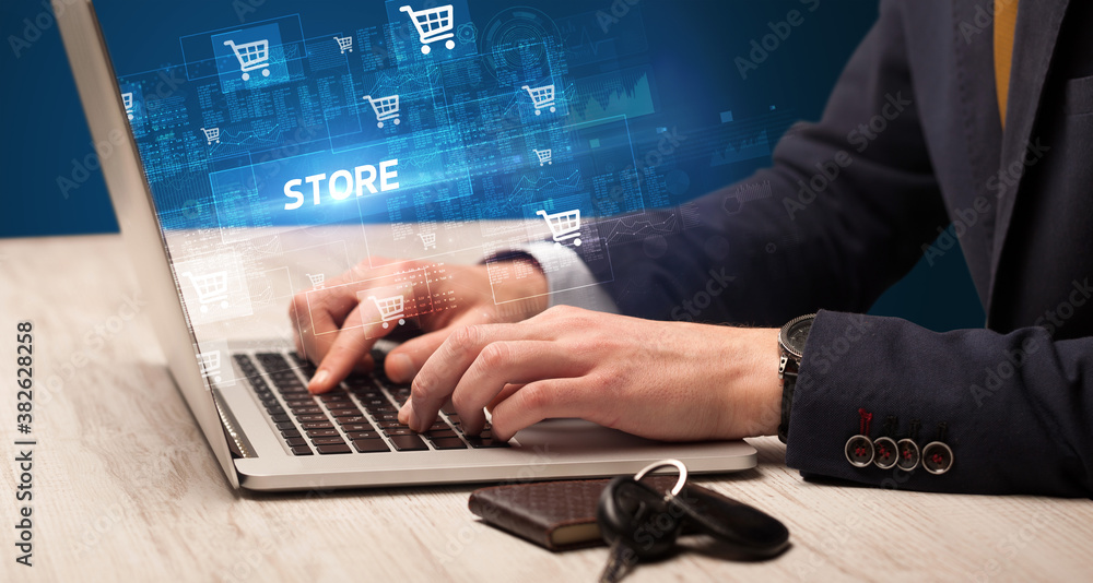Businessman working on laptop with STORE inscription, online shopping concept Businessman working on laptop with STORE inscription, online shopping concept