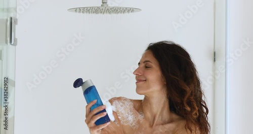 Pretty woman take shower pours gel douche into bath sponge rub neck and shoulders enjoy pleasant scent. Cleanliness bodycare, self-hygiene and healthcare using liquid product for cleaning body concept